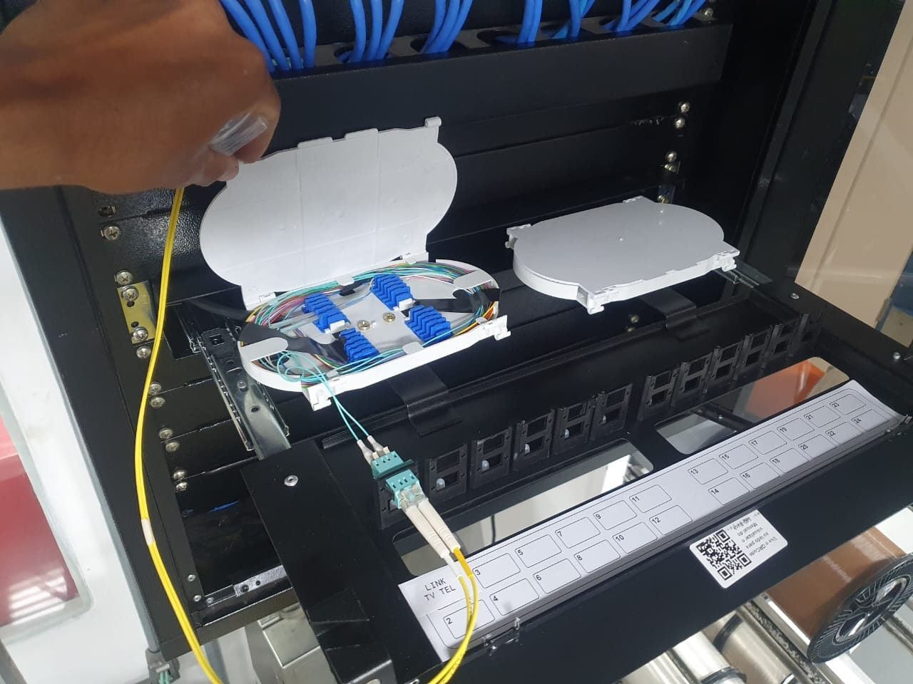 Distribuidor de fibra óptica aberto durante trabalho técnico
